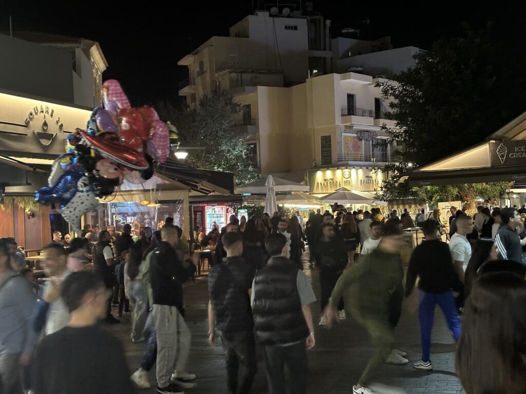 Άνθρωποι όλων των ηλικιών κάνουν την βόλτα τους, απολαμβάνοντας το φαγητό και το ποτό τους